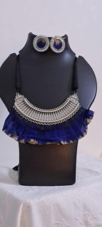 Exclusive necklace with silver oxidised big oval pendant with fabric fringes and matching earrings.