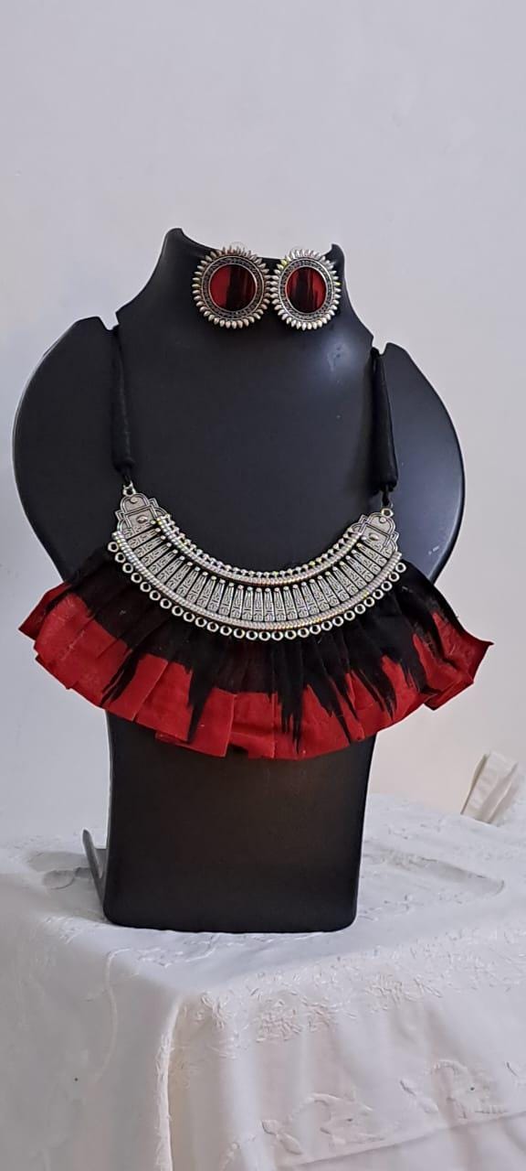 Exclusive necklace with silver oxidised big oval pendant with fabric fringes and matching earrings.