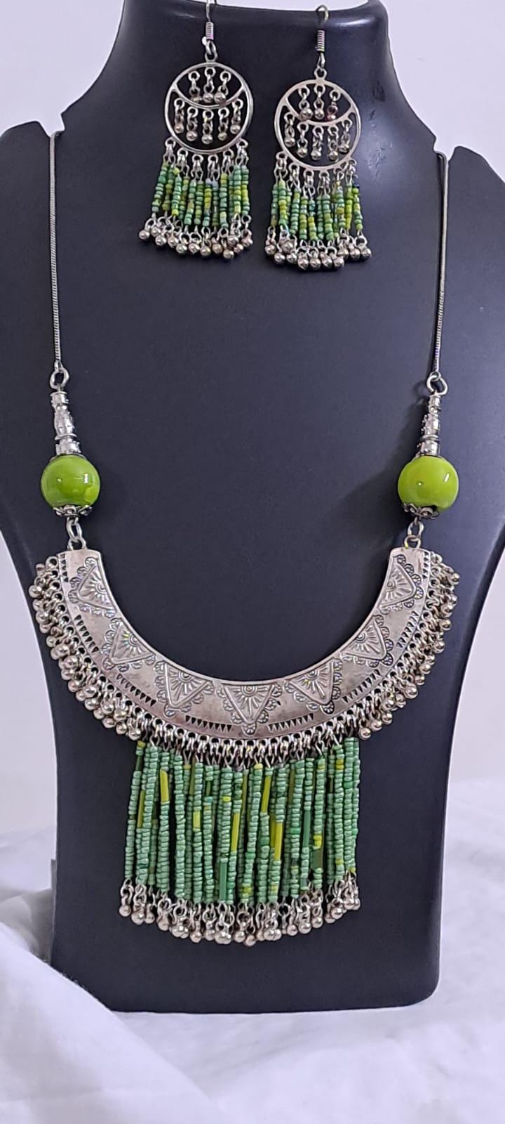 Exclusive necklace with silver oxidised big oval pendant with seed beads fringes and matching earrings.