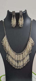 Exclusive layered off white seed beads necklace with matching hanging earrings.