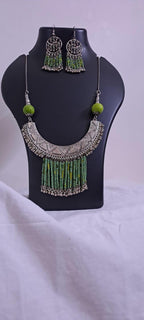 Exclusive necklace with silver oxidised big oval pendant with seed beads fringes and matching earrings.
