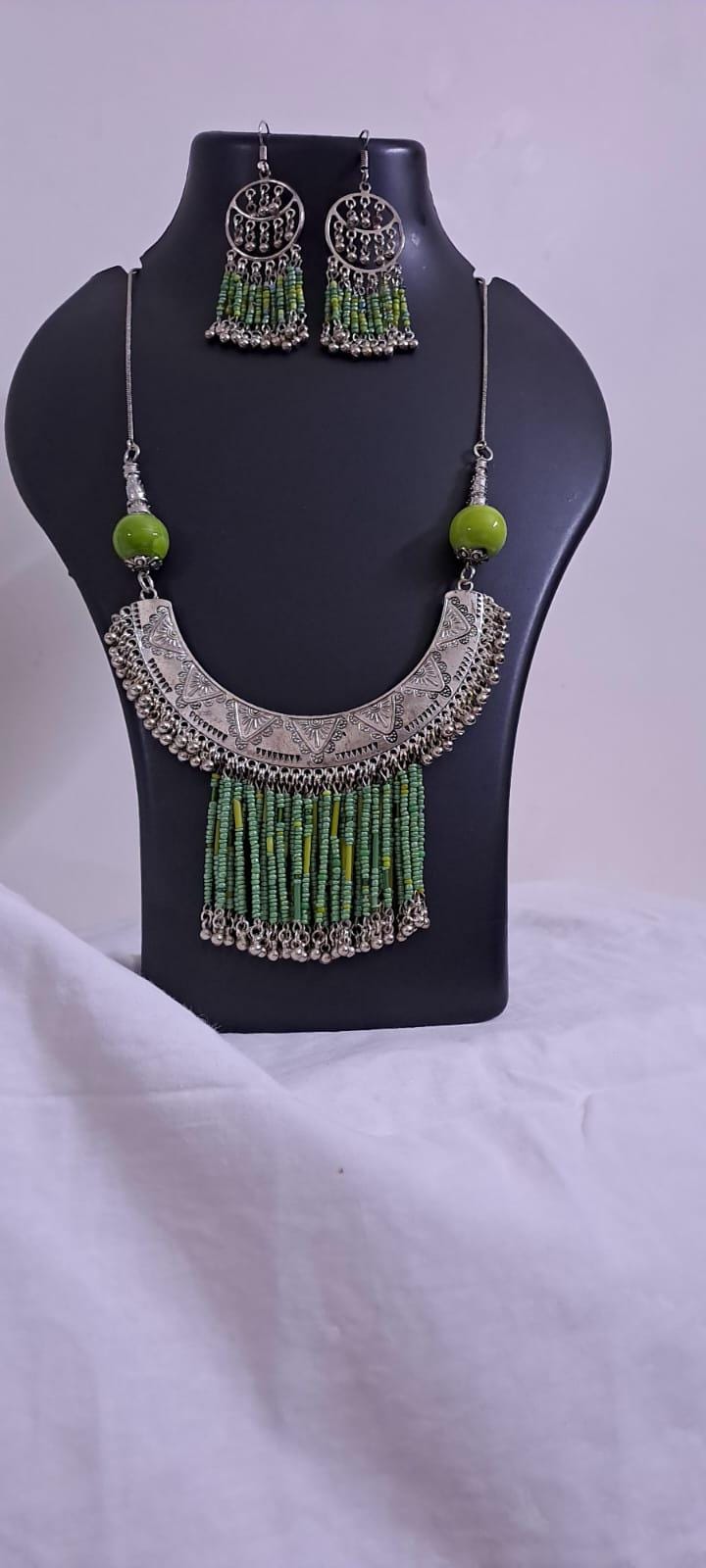 Exclusive necklace with silver oxidised big oval pendant with seed beads fringes and matching earrings.
