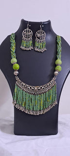 Exclusive necklace with silver oxidised big oval pendant with seed beads fringes and matching earrings.